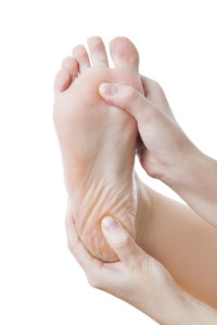 Pain in the foot. Massage of female feet. Pedicures. Isolated on white background.